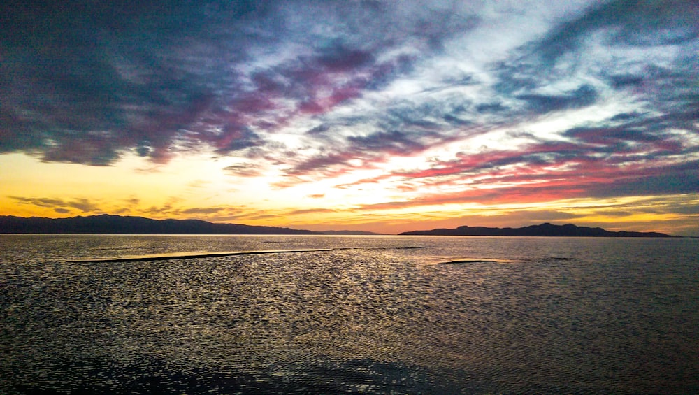 panoramic photography of body of water under golden hour