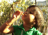 A joyful child blowing bubbles with friends, sunlight sparkling through the bubbles.