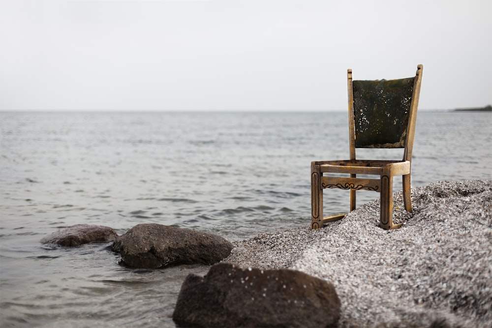 brown wooden parsons chair on gray beach sand