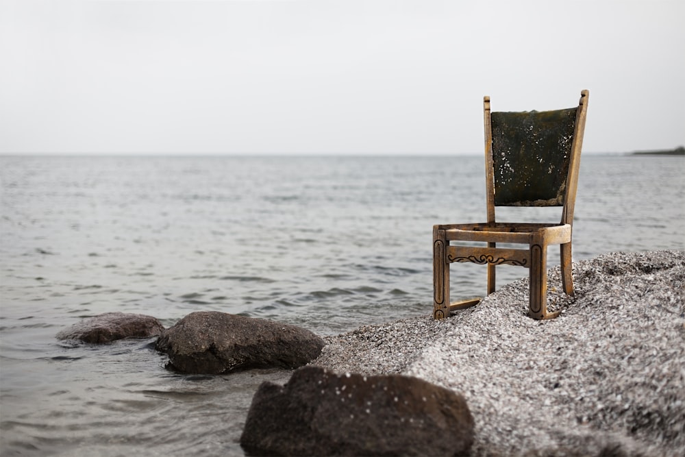 Sedia Parsons in legno marrone su sabbia grigia della spiaggia