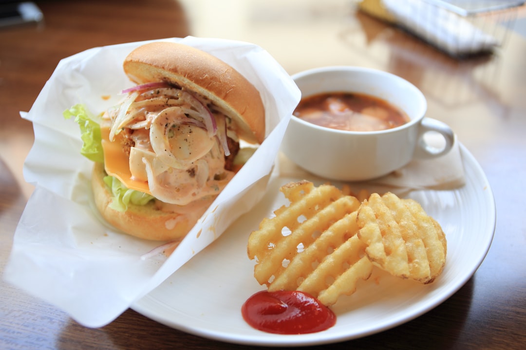 sandwich served on white ceramic plate with cup of coffee