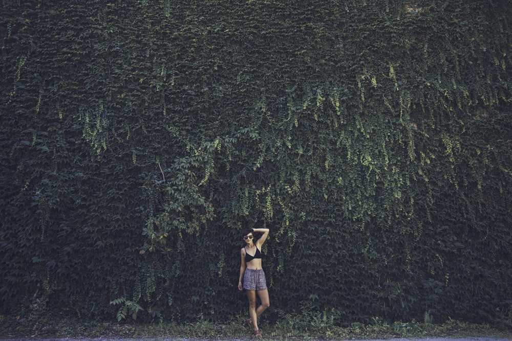 mulher usando top de biquíni preto e shorts azuis