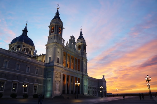 A vibrant painting of a classic cathedral bathed in warm sunset light.