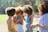 A diverse group of people happily using smartphones outdoors in a city park.