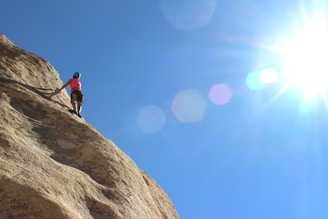 person rock climbing during day time