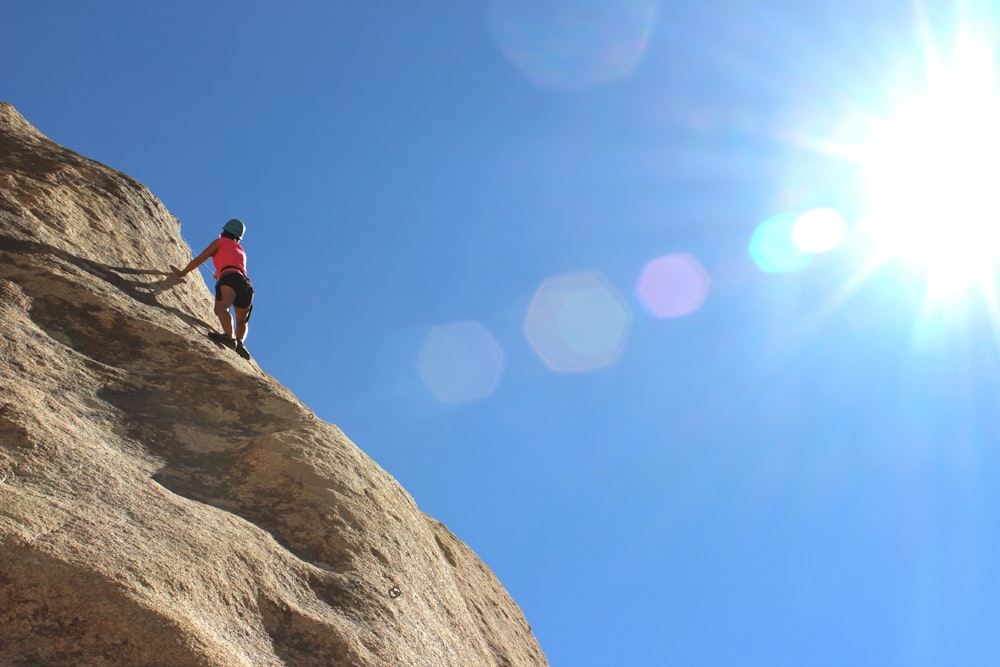 person rock climbing during day time