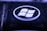 A close-up view of a key on a keyboard featuring a recognizable Windows logo. The key is predominantly black with the logo in white, encircled within a glossy surface. The lighting creates a moody, bluish-purple hue over the key, highlighting its textured surface.