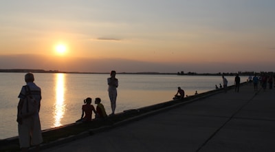 A sunset view over the lake near Bol, with silhouettes of women walking together.