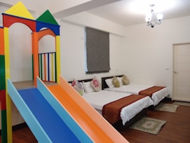 Bright family suite with multiple beds and colorful decor.
