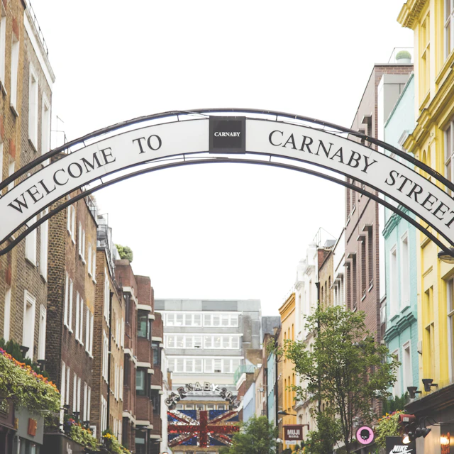 Black and white Welcome to Carnaby Street sign arching over the street in Soho, London