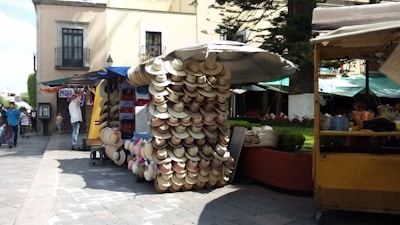 Display of hats featuring Antigua motifs stacked on a market stall.