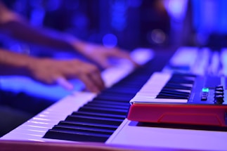 A close-up of hands playing an electronic keyboard with glowing AI-inspired graphics around.