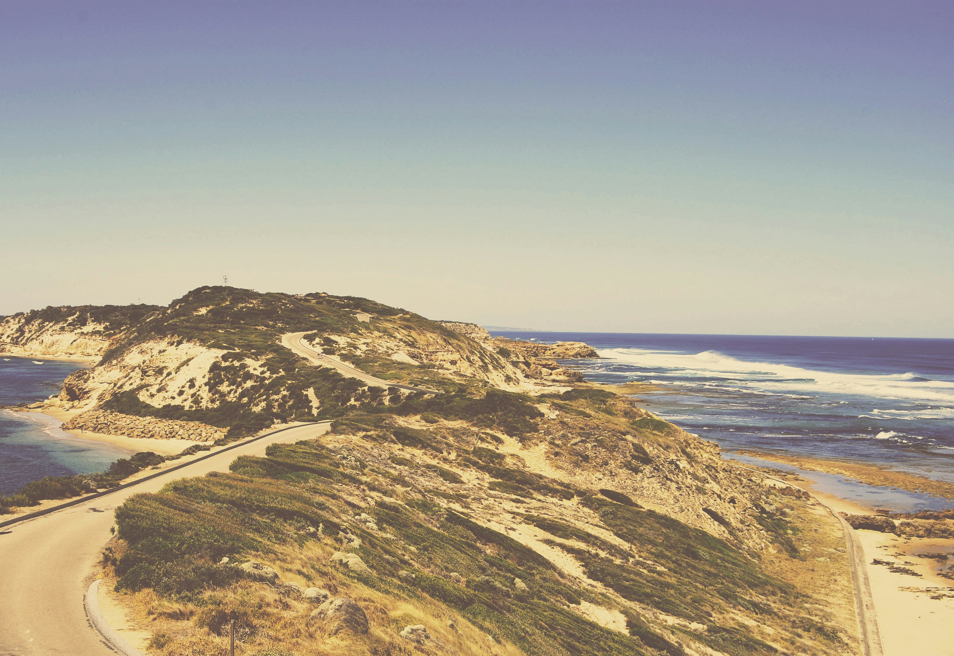 brown mountain between calm body of water, Coastline road