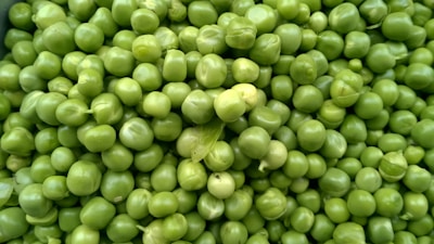 Fresh yellow peas displayed in bulk on a clean white surface.