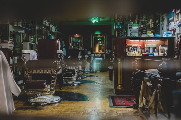 Barbershop interior with dark tones, leather chairs, and vintage barber tools.