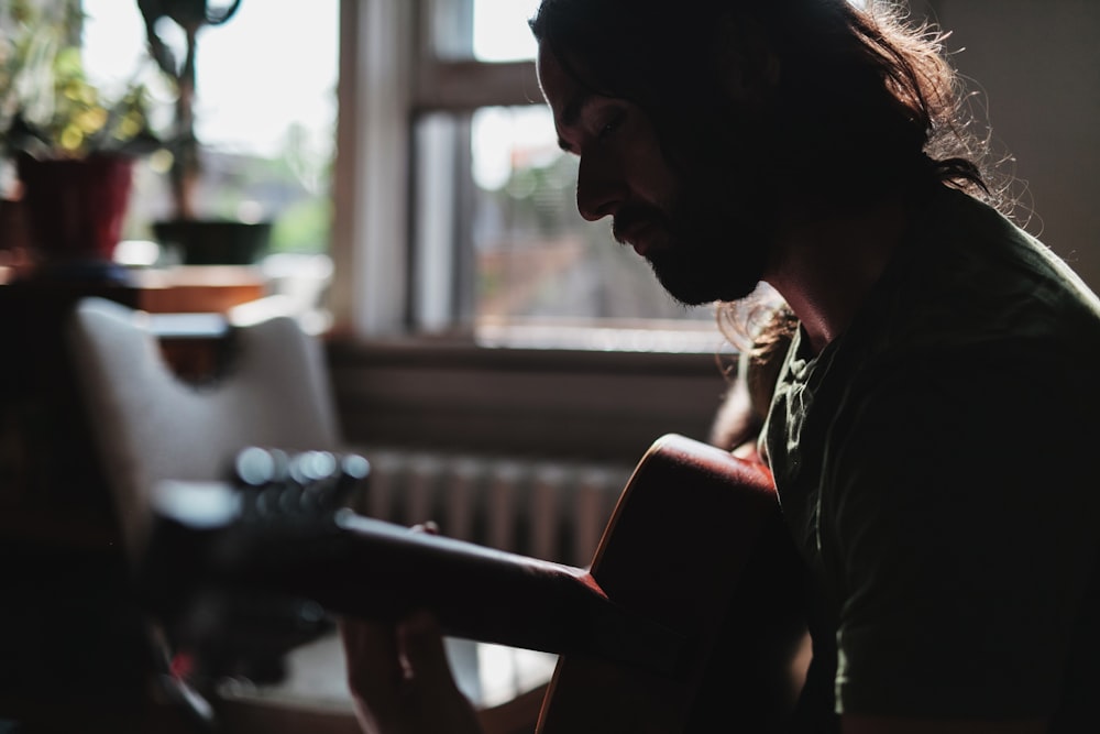 closeup photo of a man playing guitar