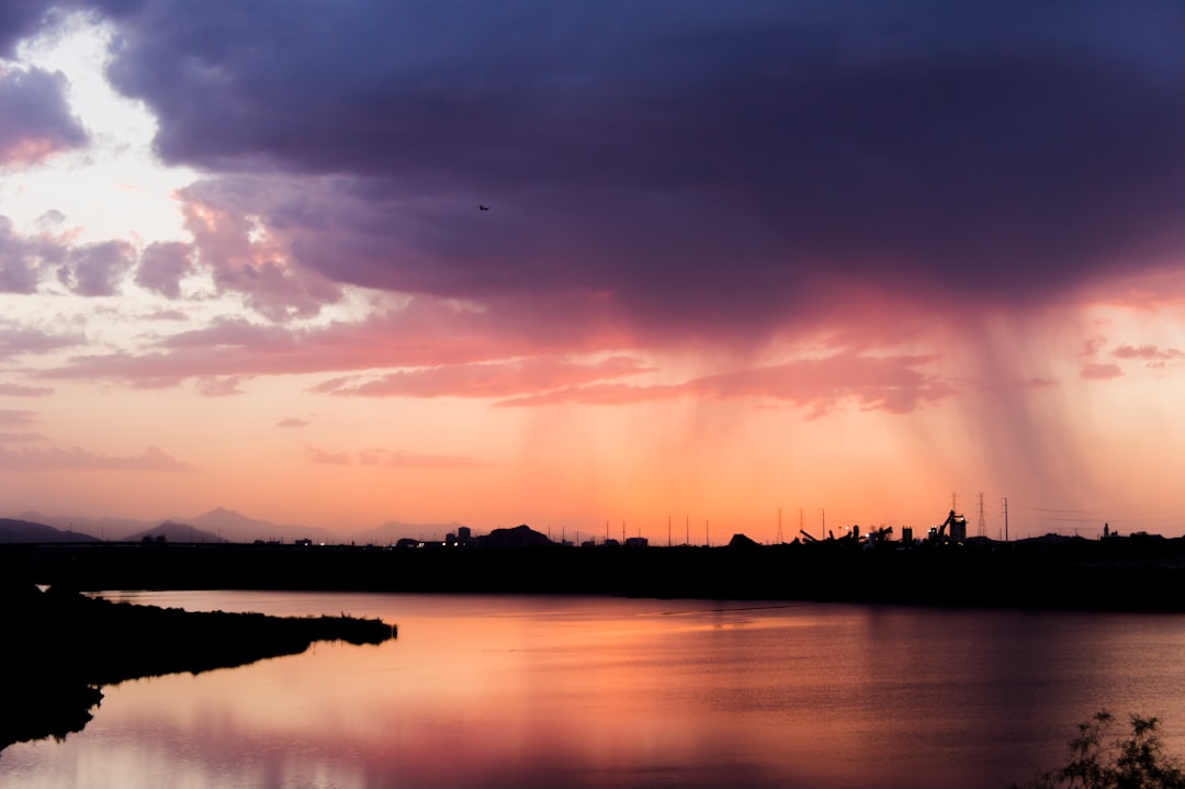 wide angle photo of body of water under cloudy sky