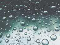 A cinematic shot of floating spheres casting soft neon glows and subtle shadows on a blurred glass surface.