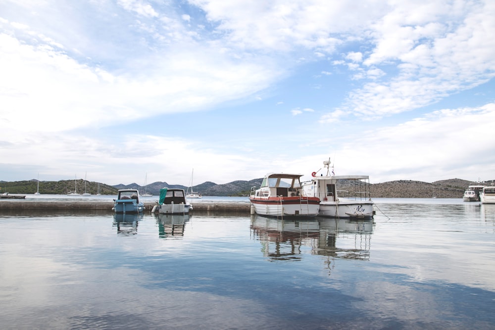 white and red boat on water under blue sky during daytime