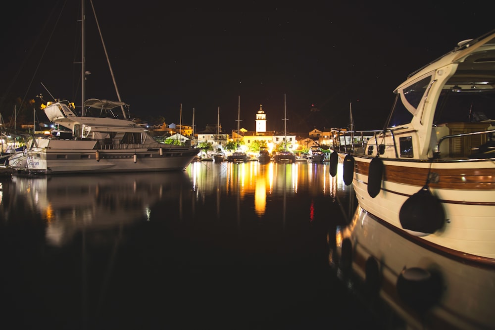 white and black boat on dock during night time