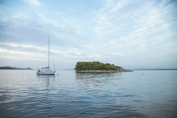 Yacht at anchor off a small wooded island