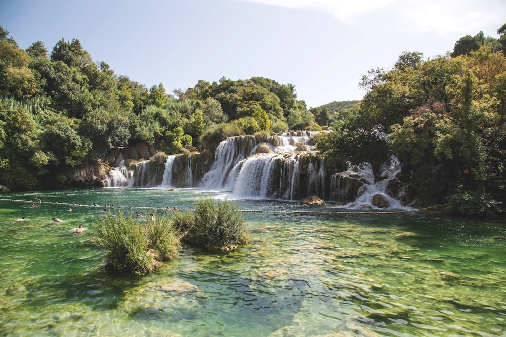 landscape photo of waterfalls flowing into river during daytime