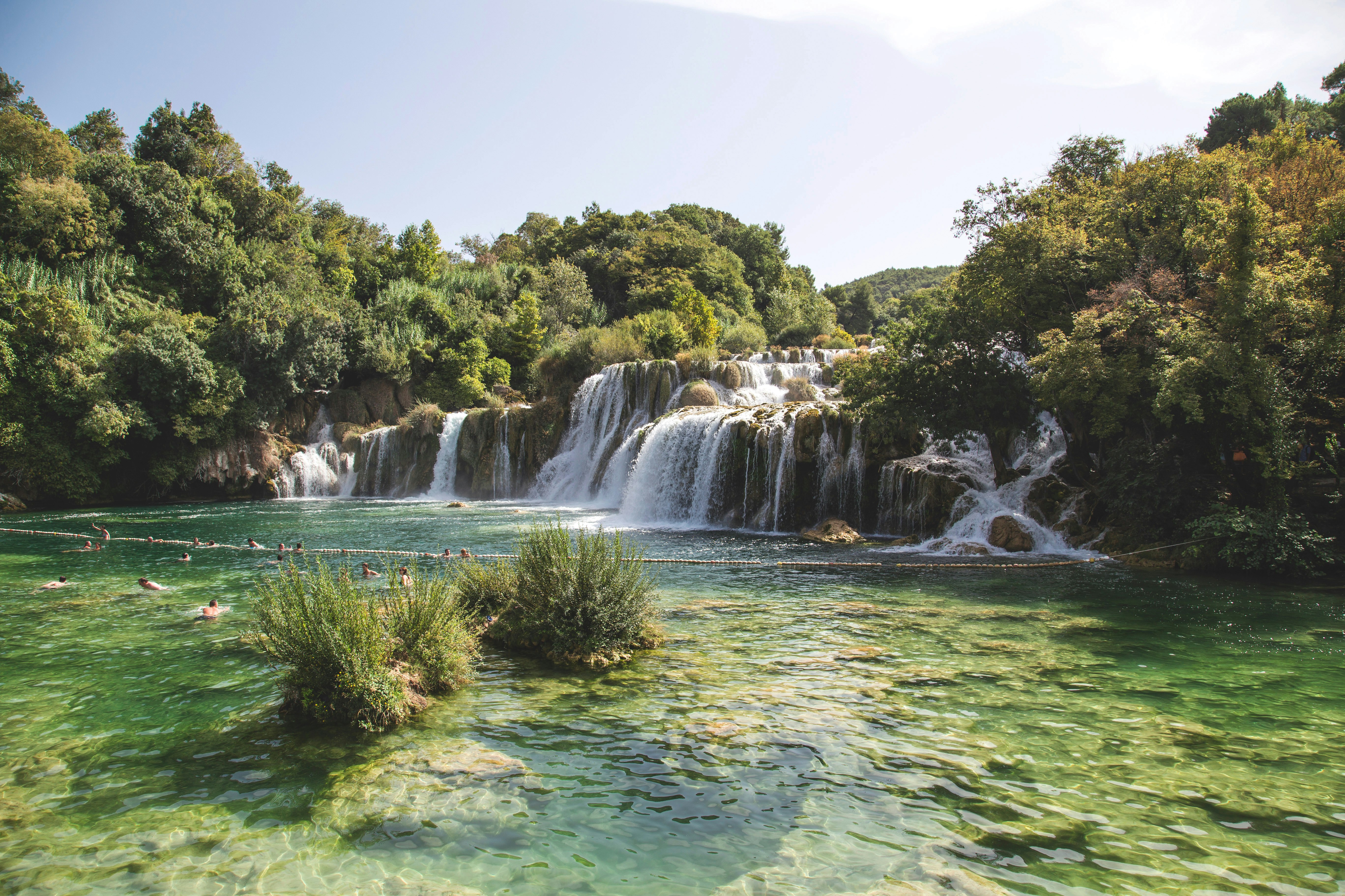 landscape photo of waterfalls flowing into river during daytime