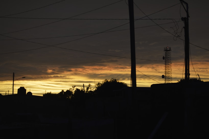 A sleek AI-generated visualization of electromagnetic waves interacting with urban telecommunication towers at dusk.