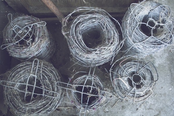 Close-up of steel wire rolls neatly stacked in a warehouse.