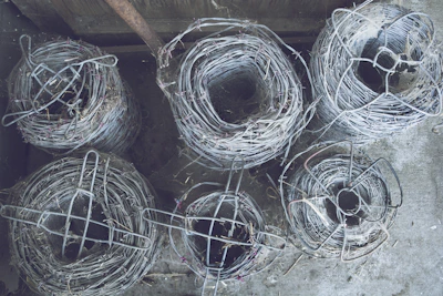 Steel coils tightly wound and ready for shipment, resting on wooden pallets in a warehouse.