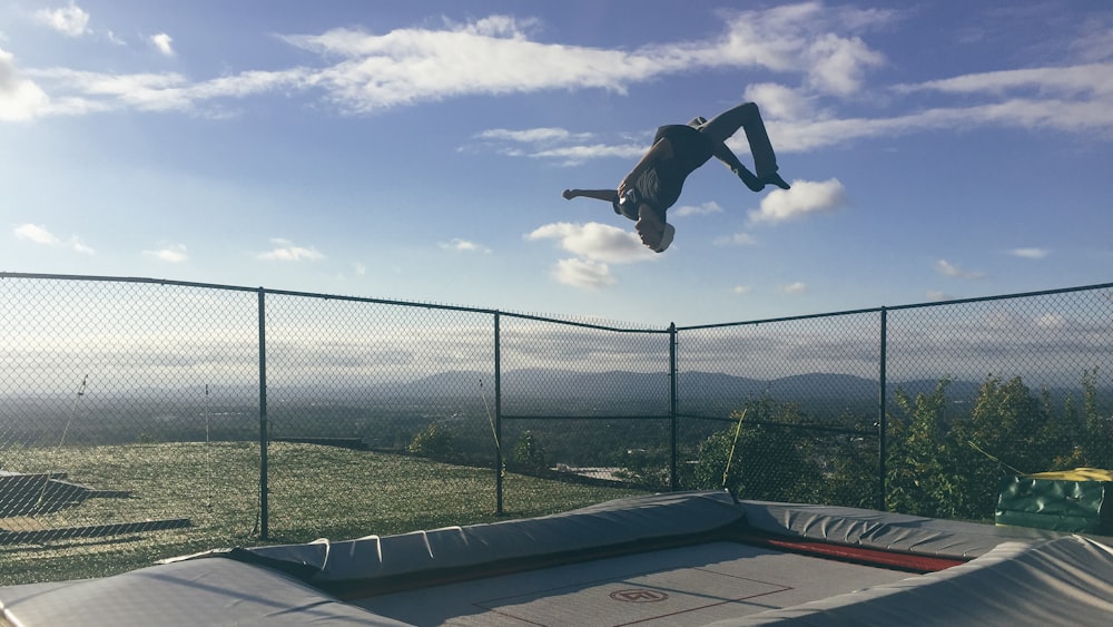 Un hombre volando por el aire mientras monta una patineta