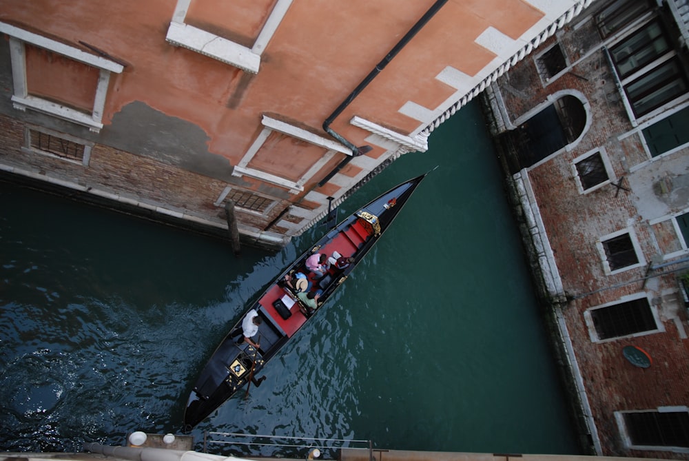 canoa negra navegando entre edificios marrones