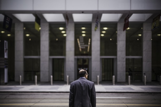 A professional handshake in front of a modern commercial building.