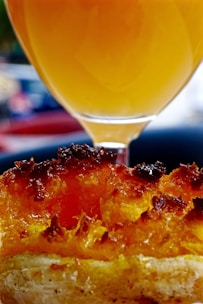 A vibrant guava pastelito with glossy fruit filling peeking from its crust.