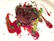 A gourmet dish featuring succulent slices of beef topped with fresh herbs, accompanied by asparagus spears and a dark red sauce artfully spread on the plate.