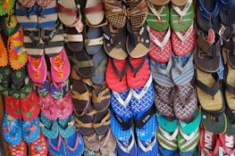 Display of various eco-friendly shoes and sandals made from upcycled tires.