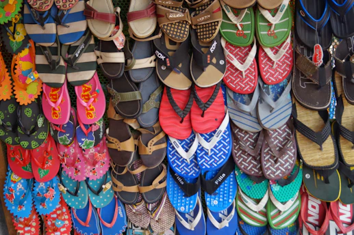 Close-up of colorful crochet sandals with tropical flowers in the background