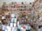 A cozy bookstore or personal library with wooden shelves filled with a vast array of books, from fiction to non-fiction. A globe sits prominently on a table, surrounded by more books and a lamp. The shelves are packed to the brim, indicating a love for literature and exploration.