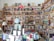 A cozy bookstore or personal library with wooden shelves filled with a vast array of books, from fiction to non-fiction. A globe sits prominently on a table, surrounded by more books and a lamp. The shelves are packed to the brim, indicating a love for literature and exploration.
