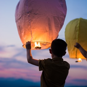 person holding yellow flammable balloon