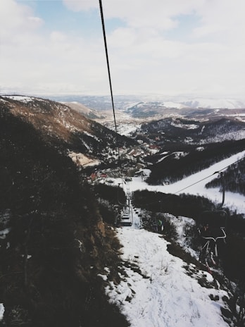 A panoramic view of a snowy mountain landscape with a ski resort in the foreground.