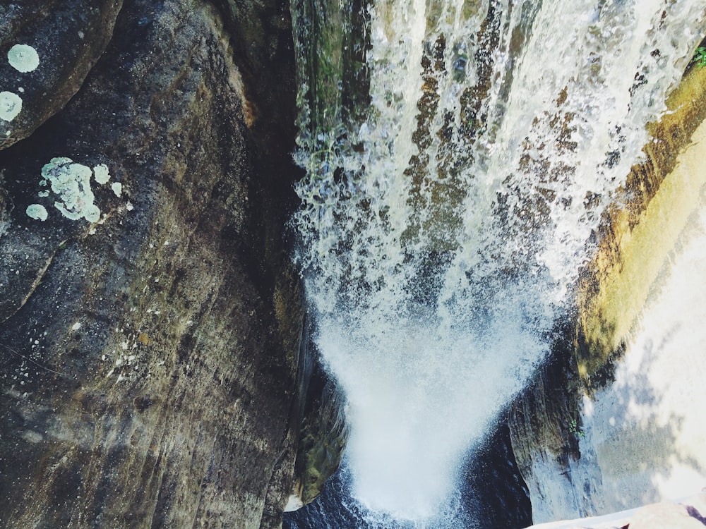 aerial photography of waterfalls surrounded by rock walls