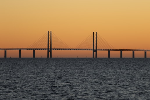 bridge during sunset with body of water
