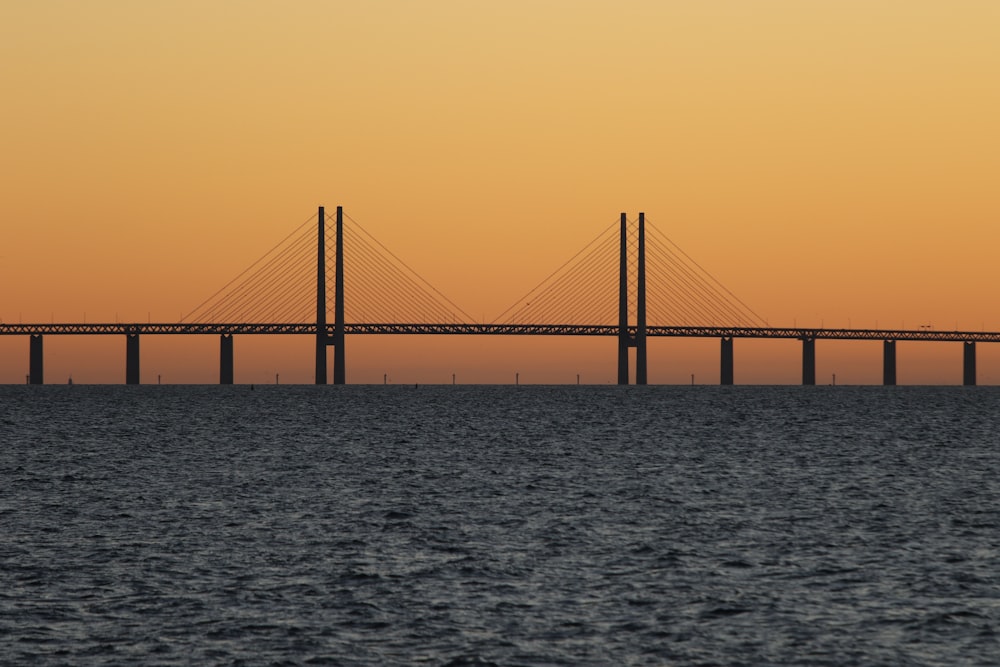 bridge during sunset with body of water