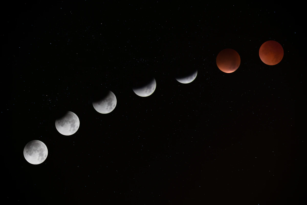 Phases d'une éclipse lunaire alignées dans un ciel étoilé, la lune passant du blanc au rouge cuivré