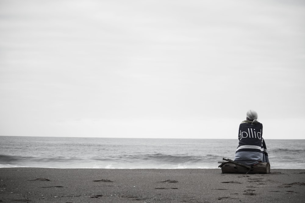 woman sitting near seashore during daytime