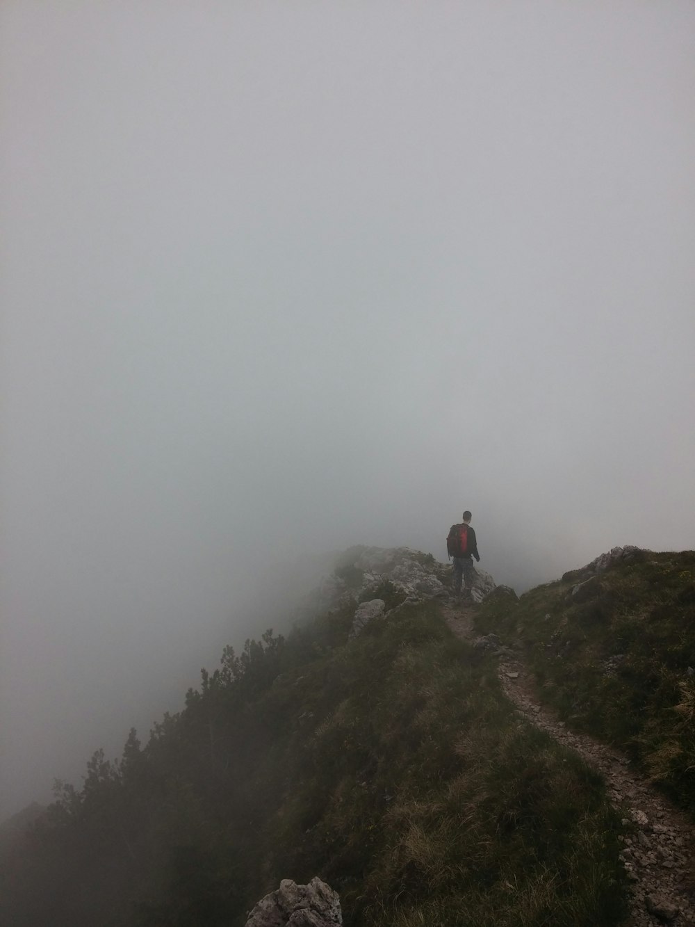 hombre de pie en la colina con niebla
