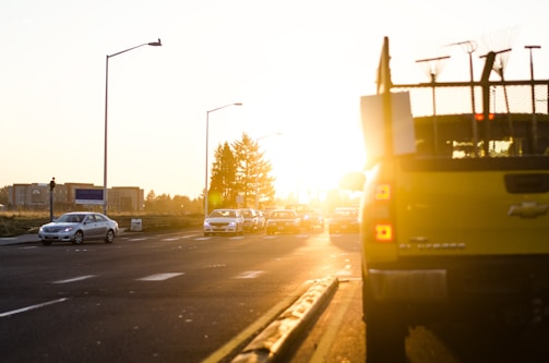 A tow truck in action on a busy city street during sunset.