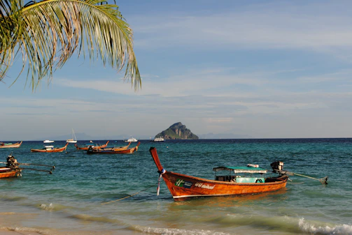 A serene beach scene on the Gili Islands with crystal-clear turquoise water and traditional fishing boats.