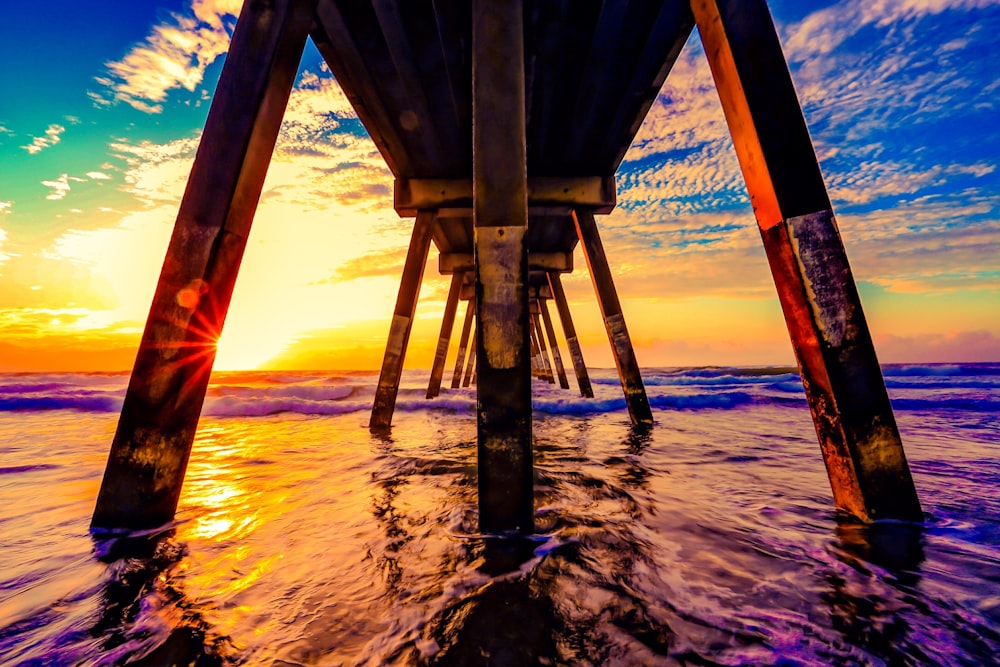 under view of brown wooden boardwalk during sunrise